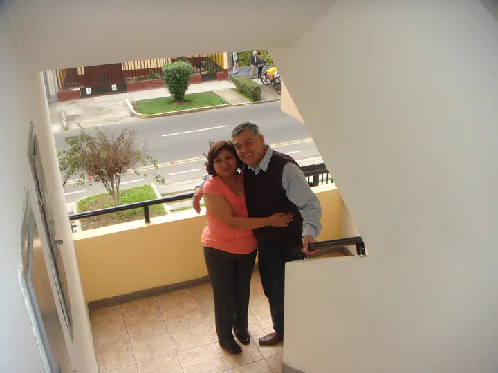 Mamá y papá posan abrazados en la escalera
